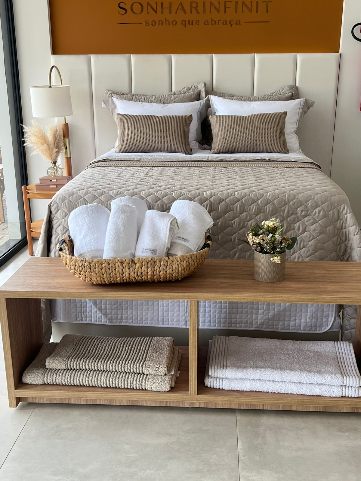 Cama neutra com toalhas brancas e decoração natural