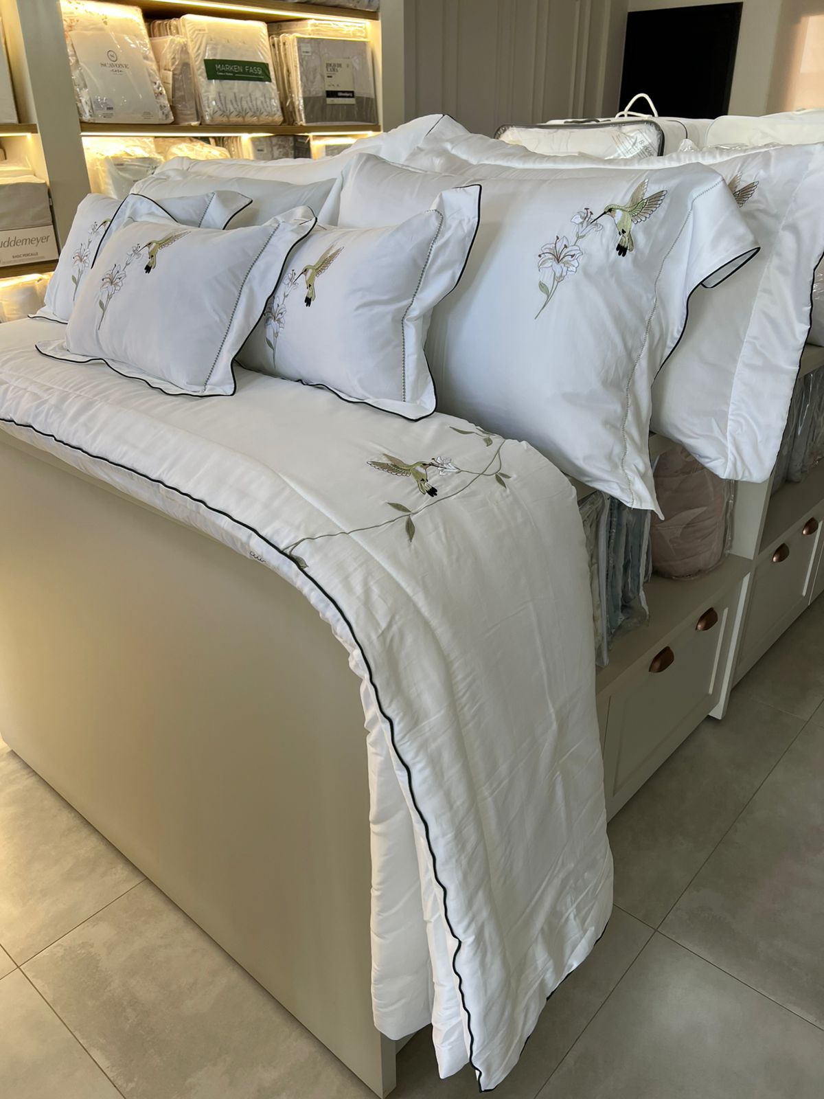 Detalhe de enxoval branco bordado com beija-flor
